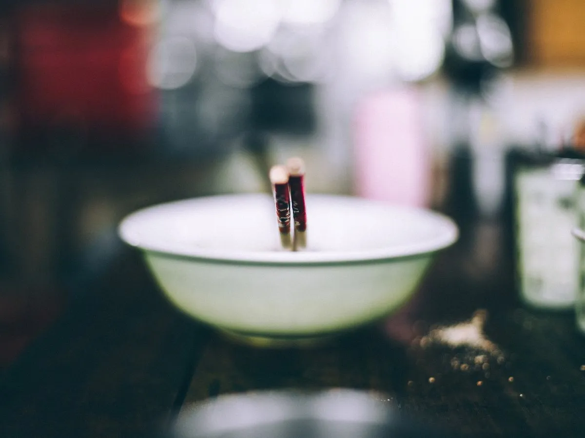 吧台上的白瓷碗和筷子，背景是暗色的店內